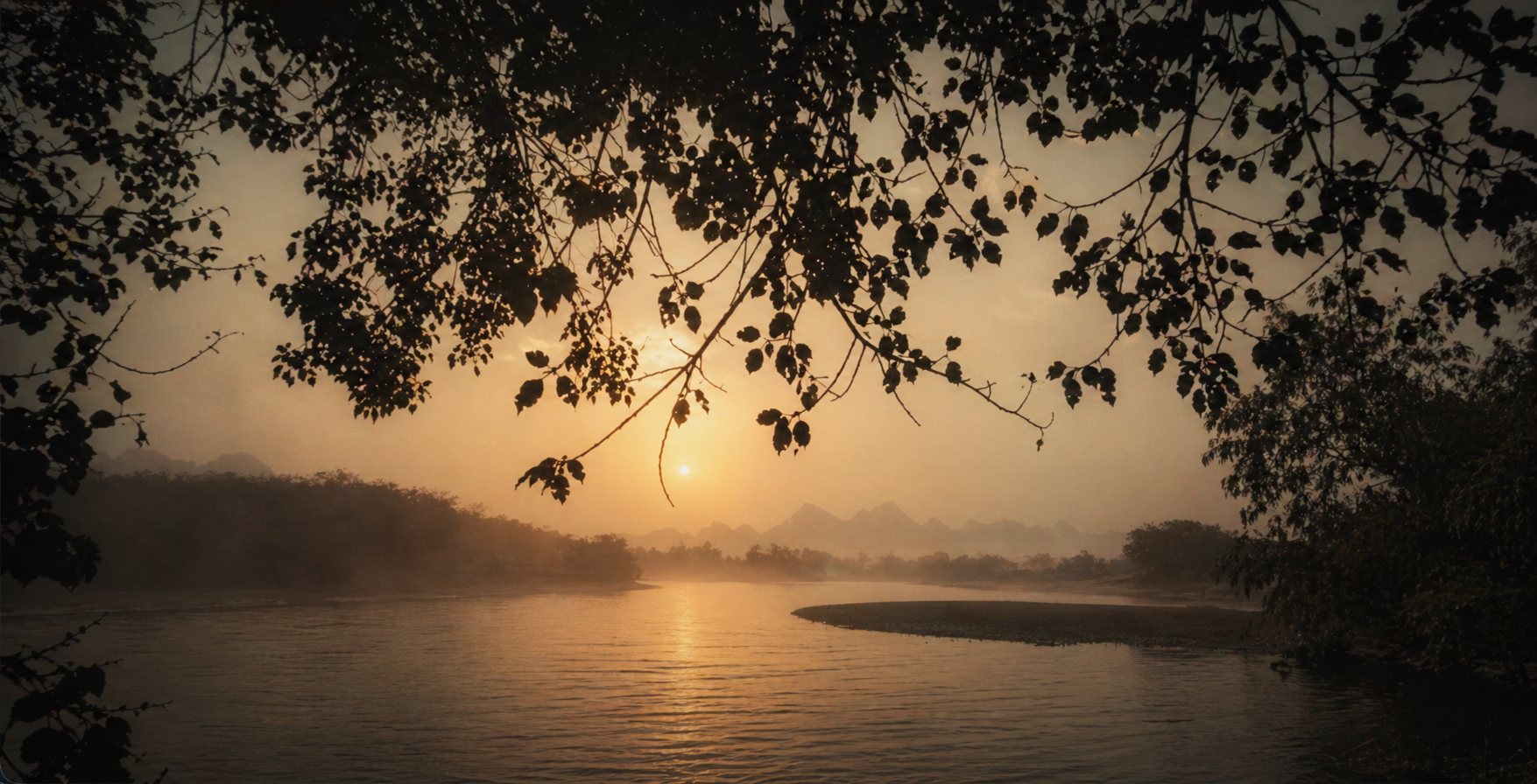 A lone figure standing at the edge of a misty lake at dawn